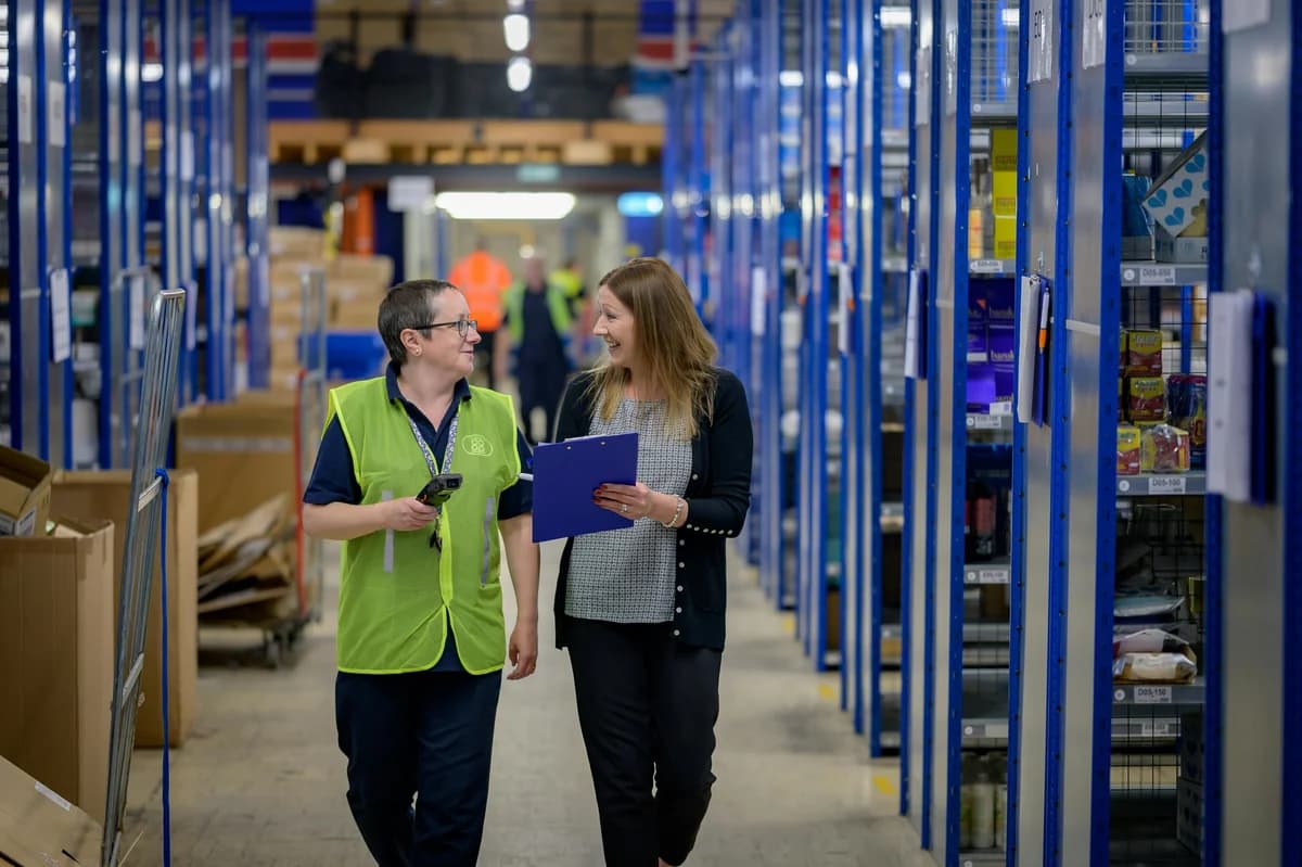 two women talking in a warehouse